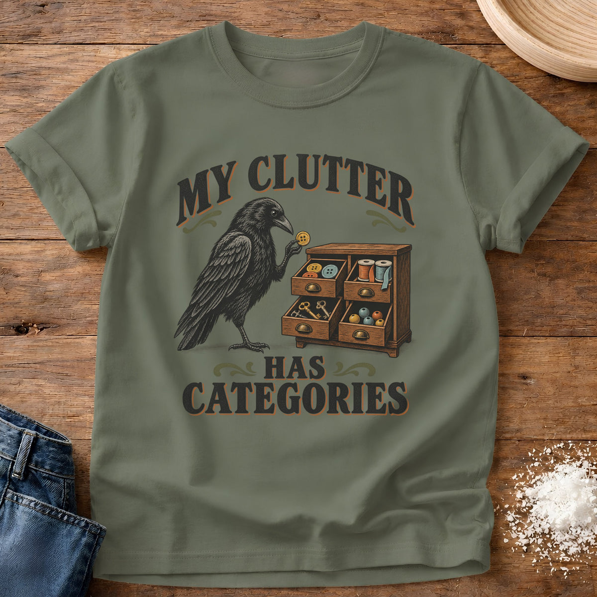 Knead More Fun Clutter Categories Crow graphic t-shirt in Moss